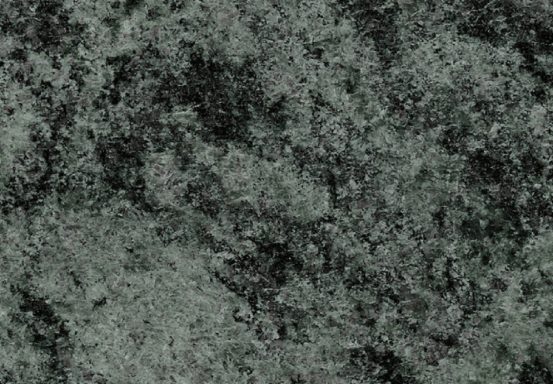 Texturierte grüne Steinoberfläche mit dunklen Einsprengseln.